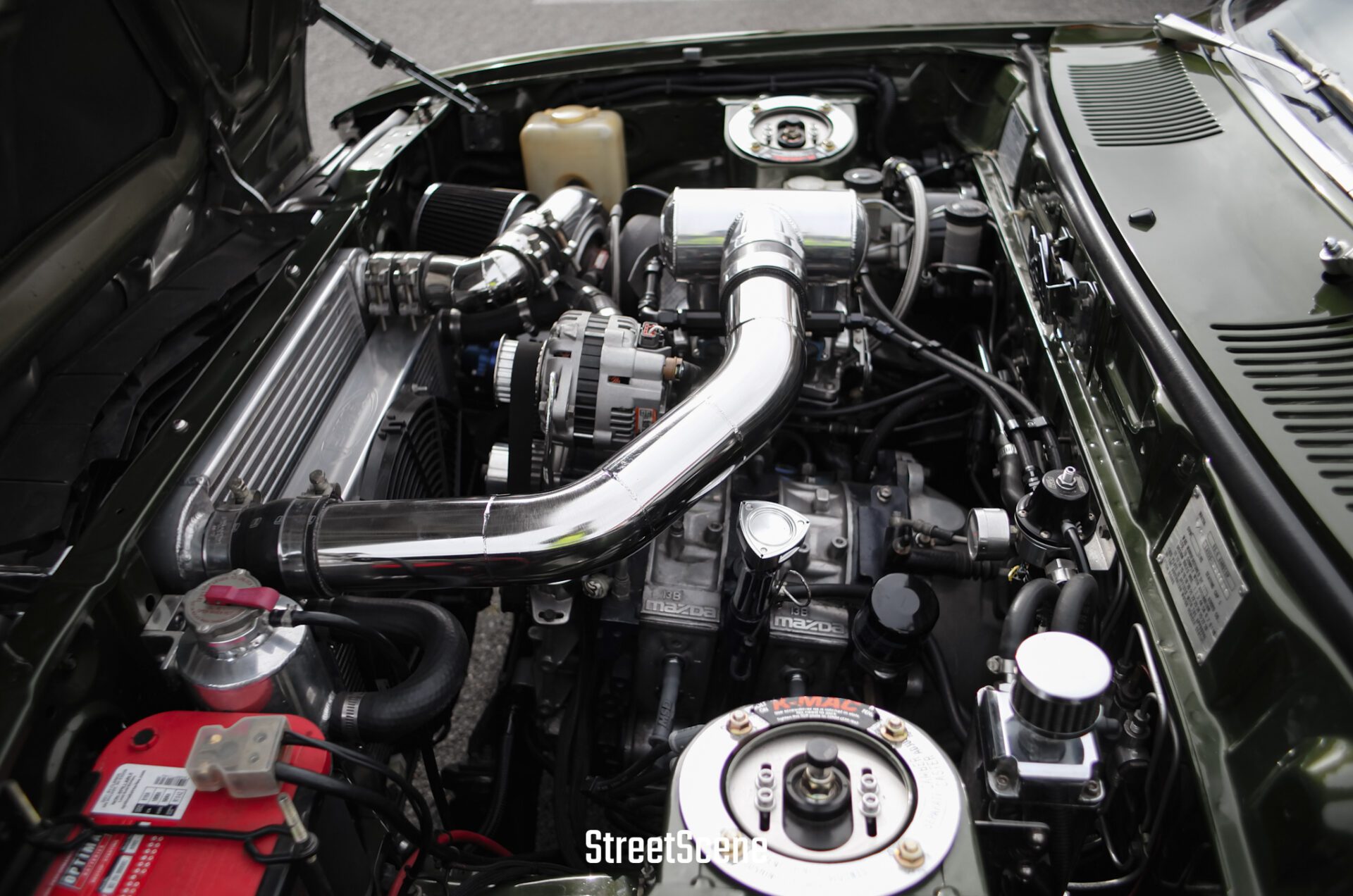 Close-up of a polished turbocharged engine bay with visible Mazda branding on components.