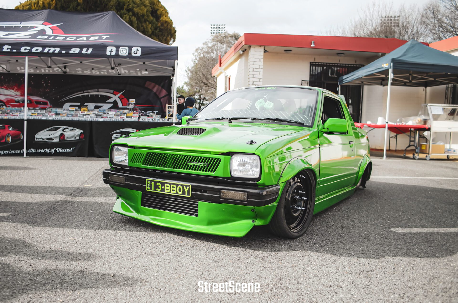 Bright green modified vintage car with lowered suspension at an outdoor car show.